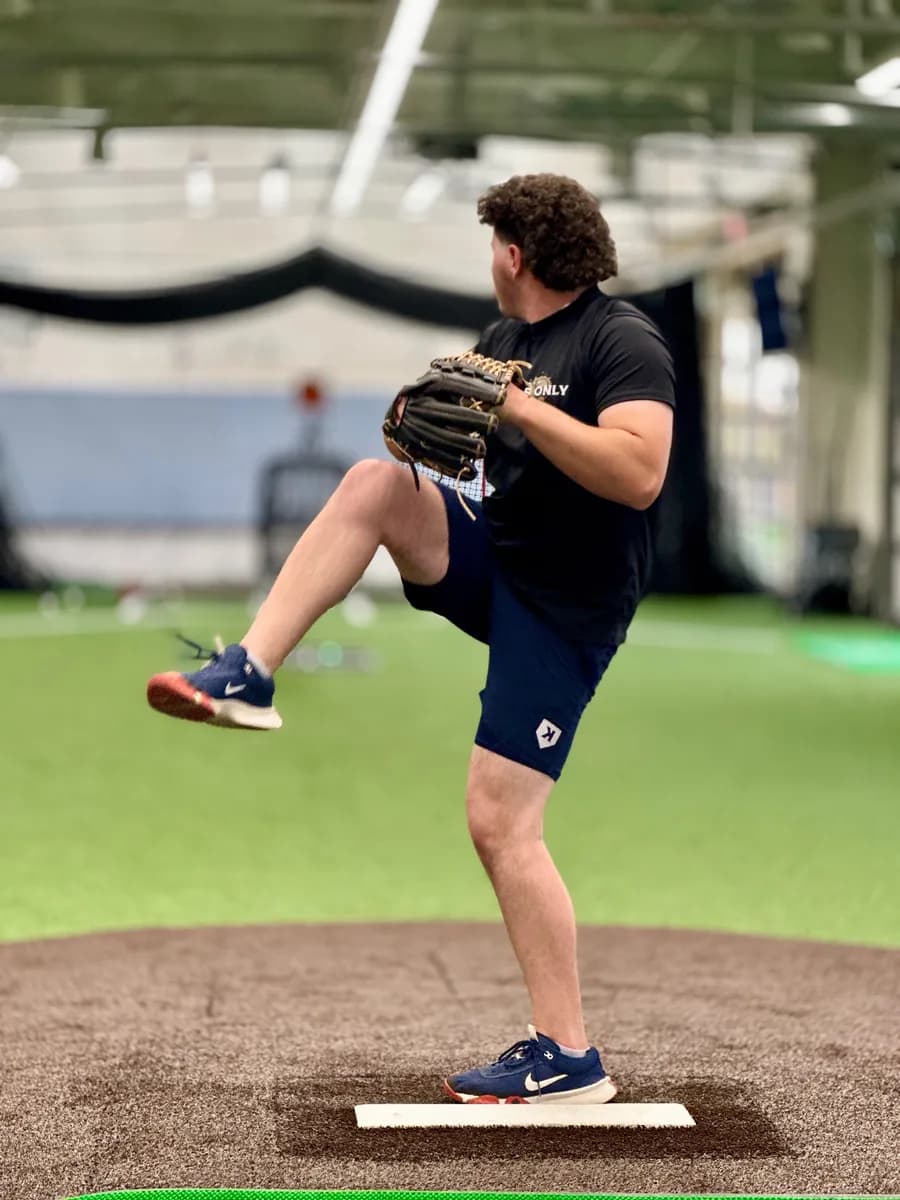 A pitcher in his leg kick on the mound at the Pitching Coach “U” facility